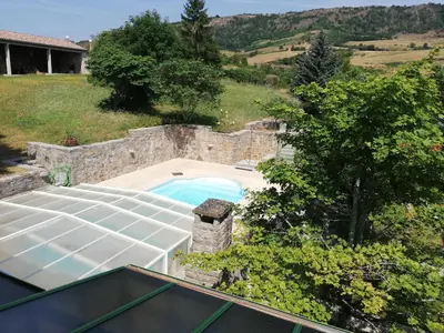 an overhead view of a swimming pool with a stone wall at Domaine des Goudis in Bouisse