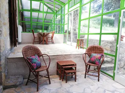 two chairs and a table in a room with windows at Domaine des Goudis in Bouisse