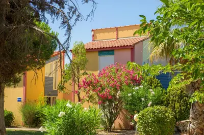a colorful house with flowers in front of it at Goélia Le Village Club Marin in Port-la-Nouvelle