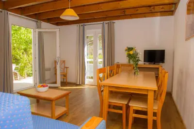 a living room with a table and chairs and a television at Goélia Le Village Club Marin in Port-la-Nouvelle