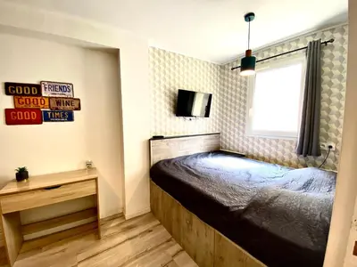 a bedroom with a bed and a tv on the wall at Bella Noche by D&O in Carcassonne
