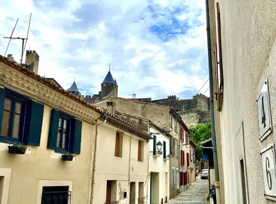 an alley with buildings with a castle in the background at Bella Noche by D&O in Carcassonne