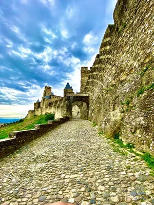 a stone road leading to a castle with a bridge at Bella Noche by D&O in Carcassonne
