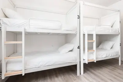 two white bunk beds in a room at Le Couvent - Hostel in Carcassonne