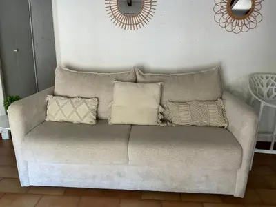a couch with pillows on it in a living room at Montez au créneau, Face à la Cité vue sublime in Carcassonne