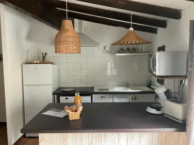 a kitchen with a table with a bottle of beer on it at Montez au créneau, Face à la Cité vue sublime in Carcassonne