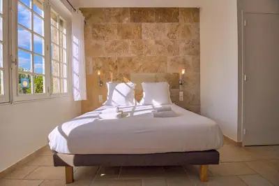a bedroom with a large bed with a stone wall at GOOD KNIGHT in Carcassonne