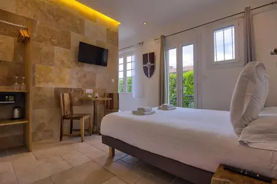 a bedroom with a large bed and a tv on a wall at GOOD KNIGHT in Carcassonne
