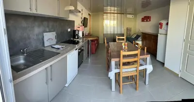 a kitchen with a sink and a table with chairs at GITE Florence et Francis in Cuxac-dʼAude