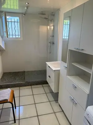 a white bathroom with a shower and a sink at GITE Florence et Francis in Cuxac-dʼAude