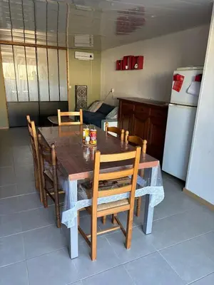 a dining room table with chairs and a kitchen at B & B Florence et Francis in Cuxac-dʼAude