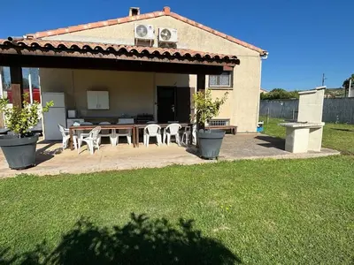 a patio with a table and chairs in front of a house at B & B Florence et Francis in Cuxac-dʼAude