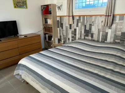 a bedroom with a bed and a tv and a window at B & B Florence et Francis in Cuxac-dʼAude