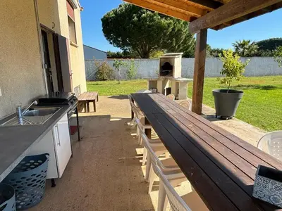 a wooden bench on a patio with a grill at B & B Florence et Francis in Cuxac-dʼAude