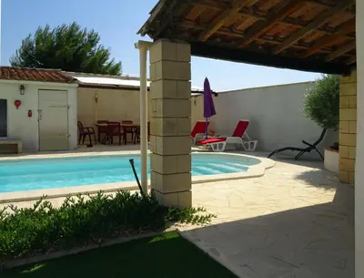 a swimming pool in a yard with a patio at Studio l'Obrador 25 m2 - Cuisine & terrasse - accès piscine in Rieux-Minervois