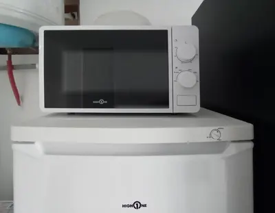 a microwave sitting on top of a white refrigerator at Studio l'Obrador 25 m2 - Cuisine & terrasse - accès piscine in Rieux-Minervois