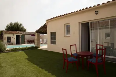 a patio with red chairs and a table in a yard at Studio l'Obrador 25 m2 - Cuisine & terrasse - accès piscine in Rieux-Minervois