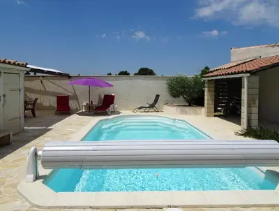a swimming pool in a patio with an umbrella at Studio l'Obrador 25 m2 - Cuisine & terrasse - accès piscine in Rieux-Minervois