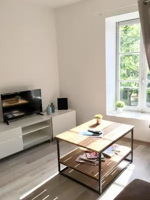 a living room with a coffee table and a tv at Le cocon de Lenny in Conques-sur-Orbiel