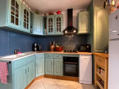 a kitchen with blue cabinets and a white refrigerator at Villa in Caunes-Minervois with Private Pool in Caunes-Minervois