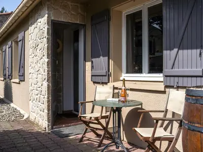 a table with two chairs and a bottle of wine on a patio at Villa in Caunes-Minervois with Private Pool in Caunes-Minervois