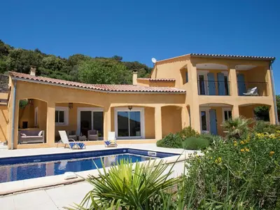 a house with a swimming pool in front of it at Roquebrun Villa with Pool in Roquebrun
