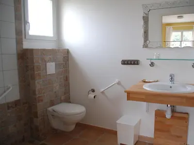 a bathroom with a toilet and a sink and a mirror at Comfortable villa with jacuzzi in Montbrun-des-Corbières