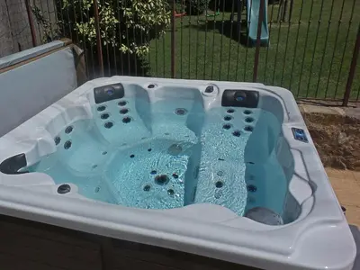 a bath tub filled with water in front of a fence at Comfortable villa with jacuzzi in Montbrun-des-Corbières