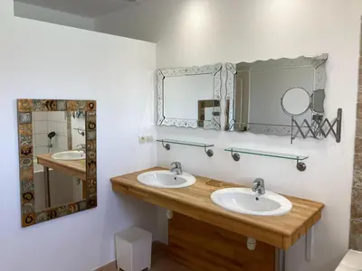 a bathroom with two sinks and two mirrors at Cosy villa with pool in Montbrun-des-Corbières