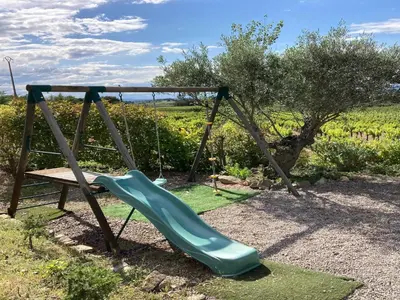 a playground with a slide and a bench at Cosy villa with pool in Montbrun-des-Corbières