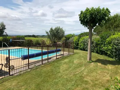 a metal fence with a pool in a yard at Cosy villa with pool in Montbrun-des-Corbières
