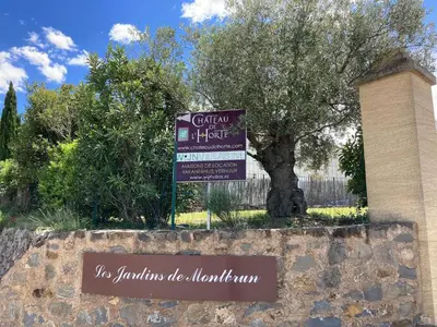 a sign in front of a building with a tree at Cosy villa with pool in Montbrun-des-Corbières