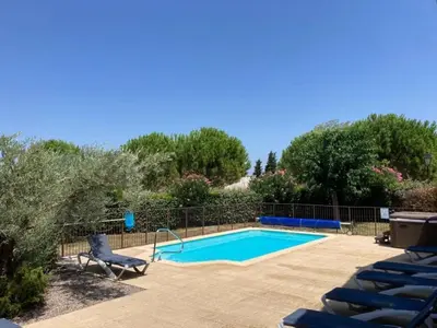 a swimming pool with blue chairs next to at Cosy villa with pool in Montbrun-des-Corbières