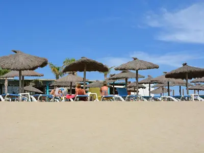 a group of chairs and umbrellas on a beach at Luxe Villa in Montbrun in Montbrun-des-Corbières