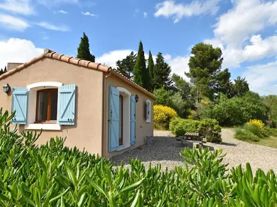 a small house with blue shutters in a garden at Luxe Villa in Montbrun in Montbrun-des-Corbières
