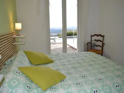 a bedroom with a bed with a view of a balcony at Tranquil Vineyard Villa, Berlou in Berlou