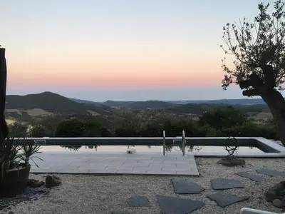 a swimming pool with a sunset in the background at Tranquil Vineyard Villa, Berlou in Berlou