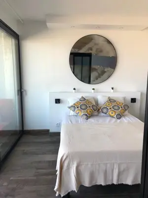 a bedroom with a bed with a mirror on the wall at Appartement Vue Mer climatisé 2 chambres in Port-la-Nouvelle