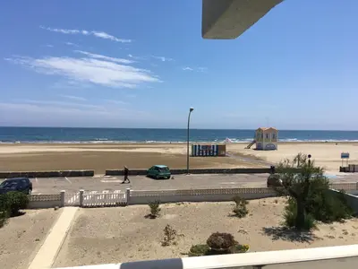 a person walking on the beach near the ocean at Appartement Vue Mer climatisé 2 chambres in Port-la-Nouvelle
