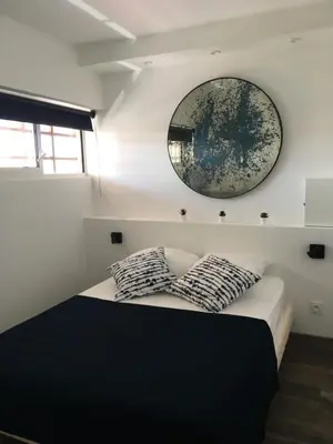 a bedroom with a bed with a mirror on the wall at Appartement Vue Mer climatisé 2 chambres in Port-la-Nouvelle