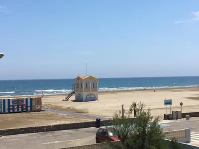 a building on the beach with the ocean in the background at Appartement Vue Mer climatisé 2 chambres in Port-la-Nouvelle