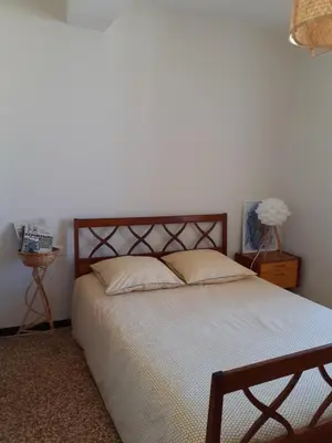 a bedroom with a large bed with white sheets at Le Nid de Jeanne in Lézignan-Corbières