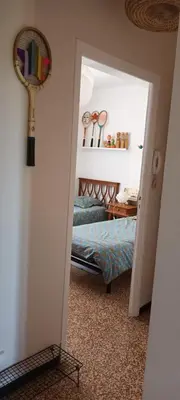 a bedroom with a bed and a racket on the wall at Le Nid de Jeanne in Lézignan-Corbières