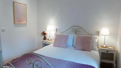 a bedroom with a bed with pink and white pillows at Gîtes de Montcabirol in Mirepoix