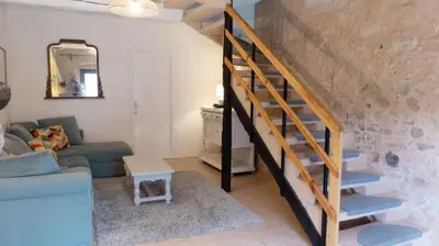 a staircase in a living room with a blue couch at Gîtes de Montcabirol in Mirepoix