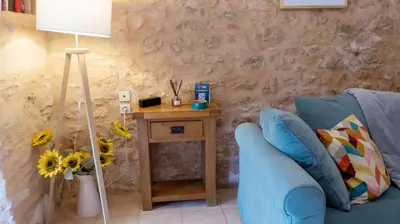 a living room with a blue couch and a table with a lamp at Gîtes de Montcabirol in Mirepoix