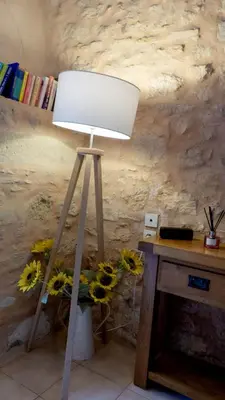 a light on a tripod next to a table with sunflowers at Gîtes de Montcabirol in Mirepoix