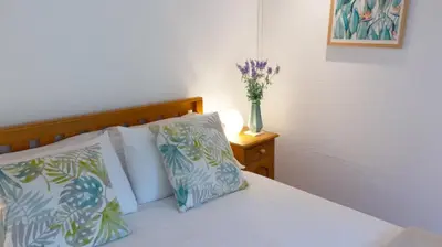 a bed with two pillows and a vase with flowers at Gîtes de Montcabirol in Mirepoix