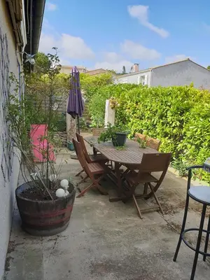 a patio with a table and chairs and an umbrella at La Maison de Fafa in Carcassonne