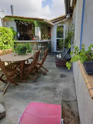 a patio with a table and chairs and a house at La Maison de Fafa in Carcassonne